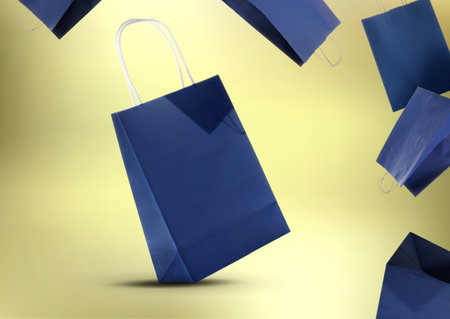 Hot sale. Blue shopping bags in air on golden gradient backgroundの写真素材