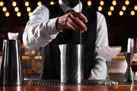 Bartender preparing fresh alcoholic cocktail at bar counter, closeupの写真素材