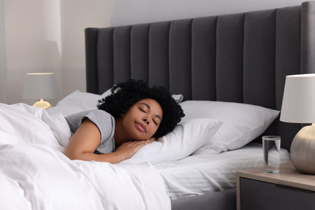 Beautiful young woman sleeping in soft bed at homeの写真素材