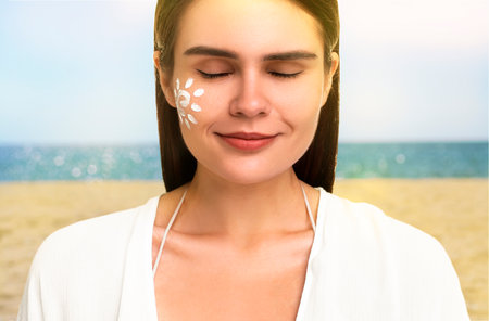 Sun protection. Beautiful young woman with sunblock on her face near sea, closeup