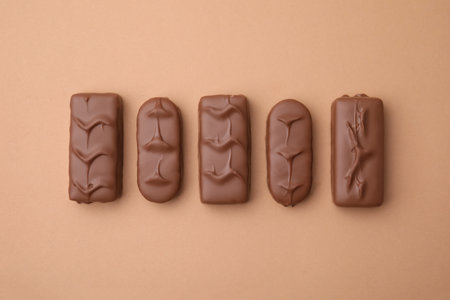 Different tasty chocolate bars on beige background, flat lay