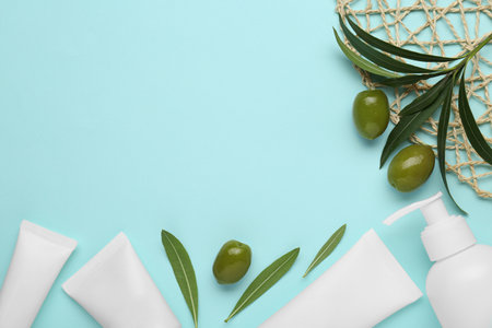 Cosmetic products with olive essential oil light turquoise background, flat lay. Space for textの写真素材