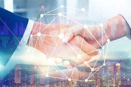 Deal or partnership concept. Multiple exposure with cityscape, charts and photo of businesspeople shaking handsの写真素材