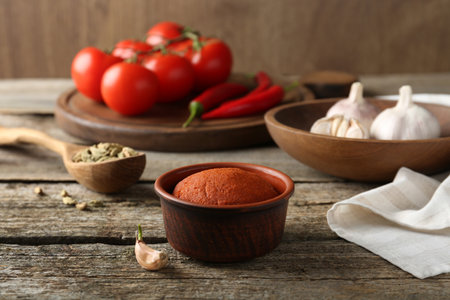 Red curry paste in bowl and ingredients on wooden tableの写真素材