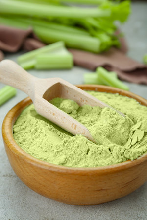 Wooden bowl and scoop with natural celery powder on gray table, closeupの写真素材