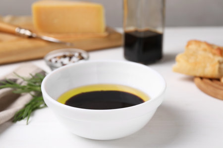 Bowl of balsamic vinegar with oil on white table, closeupの写真素材