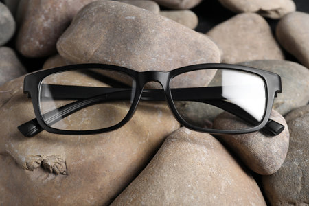 Glasses in stylish black frame on stones, closeupの写真素材