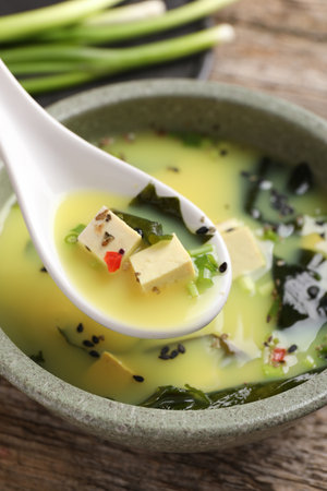Delicious miso soup with tofu in spoon above bowl, closeupの写真素材
