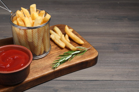 Delicious French fries served with ketchup on wooden table, space for textの写真素材