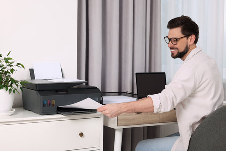 Man using modern printer at workplace indoorsの写真素材