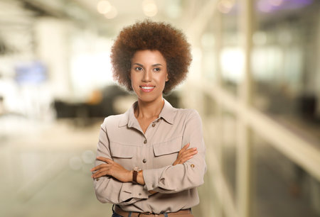 Portrait of happy woman in office. Beautiful girl smiling on blurred backgroundの写真素材