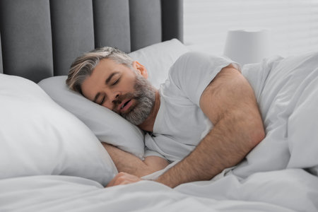 Man snoring while sleeping in bed at home