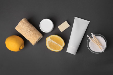 Lemon face wash. Fresh citrus fruits and personal care products on dark gray background, flat layの写真素材
