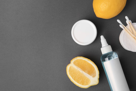 Lemon face cleanser. Fresh citrus fruits and personal care products on dark gray background, flat lay. Space for textの写真素材