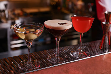 Glasses of different Martini cocktails on bar counter