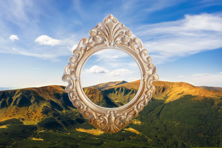 Vintage frame and beautiful mountains under blue sky with cloudsの写真素材