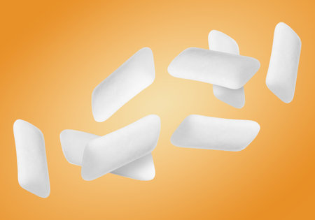 Many chewing gum pads falling on orange backgroundの写真素材