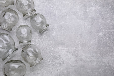 Glass cups on gray table, flat lay with space for text. Cupping therapy