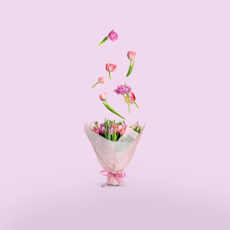 Tulip flowers falling into beautiful bouquet on pink backgroundの写真素材