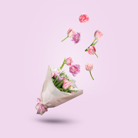 Tulip flowers falling into beautiful bouquet on pink backgroundの写真素材