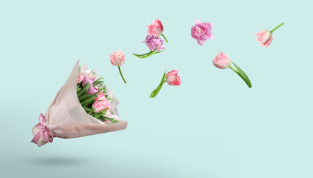 Tulip flowers flying to beautiful bouquet on light blue background, banner designの写真素材