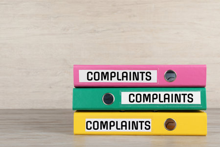 Colorful folders with Complaints labels on table, space for textの写真素材