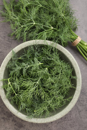 Bowl of fresh dill on gray table, flat layの写真素材