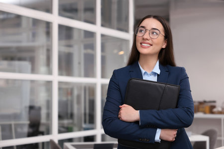 Happy real estate agent with leather portfolio indoors. Space for textの写真素材