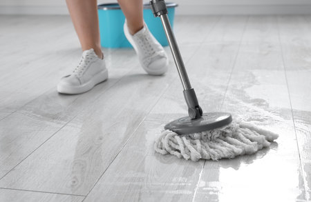 Woman floor cleaning with mop indoors, closeupの写真素材