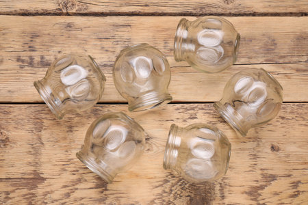 Glass cups on wooden table, flat lay. Cupping therapy