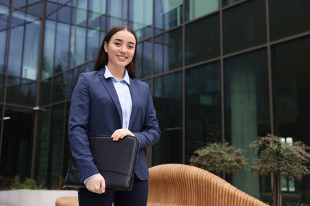 Real estate agent with leather portfolio outdoors. Space for text