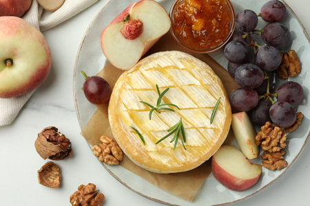 Tasty baked brie cheese served on white marble table, flat layの写真素材