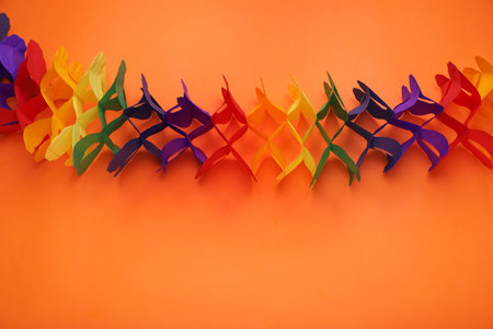 Rainbow paper garland on orange background, top view with space for text. LGBT prideの写真素材
