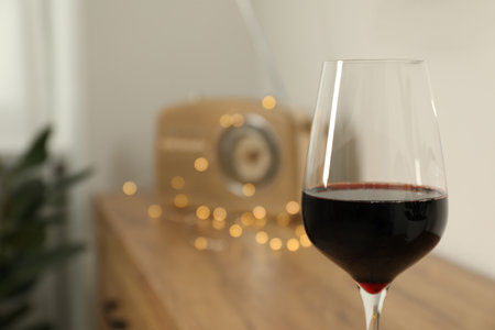 Relax at home. Glass of red wine in room, closeup. Space for textの写真素材