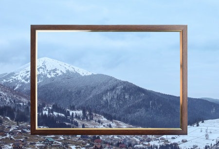 Wooden frame and beautiful mountains covered with snow in winterの写真素材