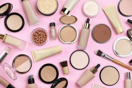 Face powders and other decorative cosmetic products on pink background, flat layの写真素材