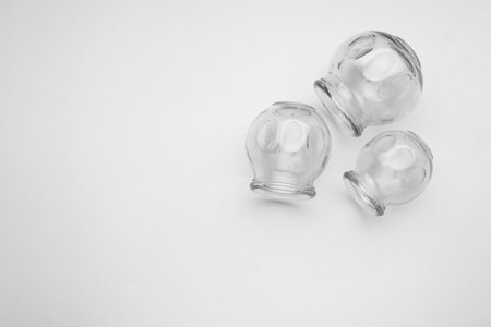 Glass cups on light gray background, flat lay and space for text. Cupping therapyの写真素材