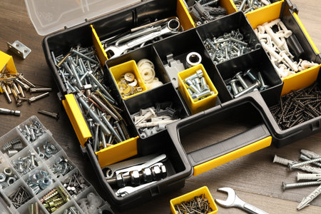 Organizers with many different fasteners and wrenches on wooden table, above viewの写真素材