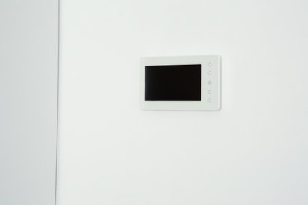 Modern video intercom hanging on white wallの写真素材