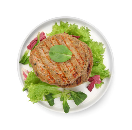 Plate of delicious vegan cutlets, lettuce and spinach isolated on white, top viewの写真素材