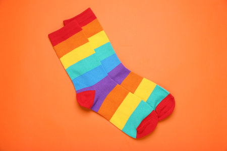 Rainbow socks on orange background, flat lay. LGBT prideの写真素材