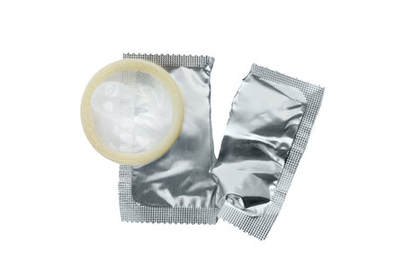 Torn package with condom isolated on white, top view. Safe sexの写真素材