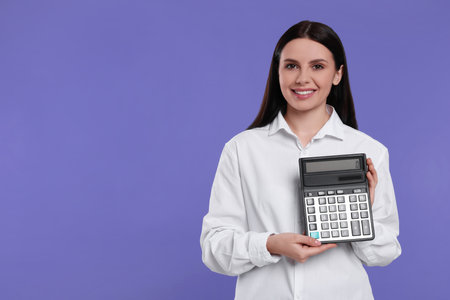 Smiling accountant with calculator on purple background, space for textの写真素材
