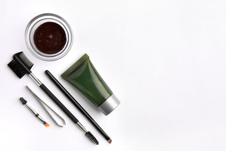 Flat lay composition with eyebrow henna, professional tools and cosmetic product on white background, space for textの写真素材