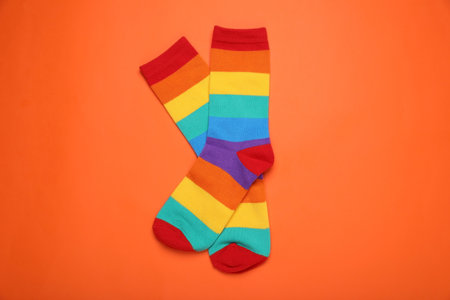 Rainbow socks on orange background, flat lay. LGBT prideの写真素材