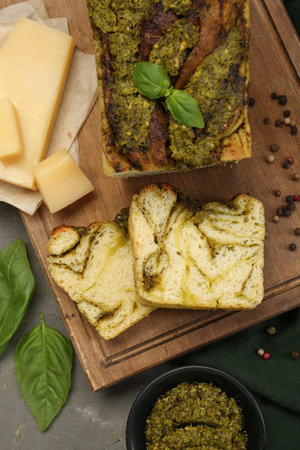 Freshly baked pesto bread with ingredients on gray table, flat layの写真素材