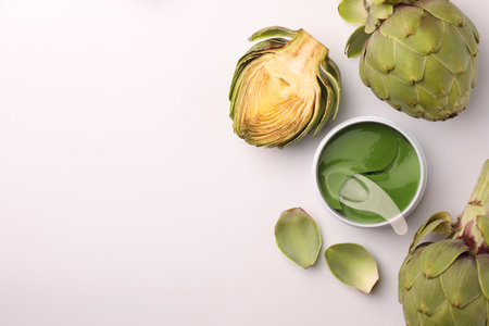 Package of under eye patches and artichokes on white background, top view. Cosmetic productの写真素材