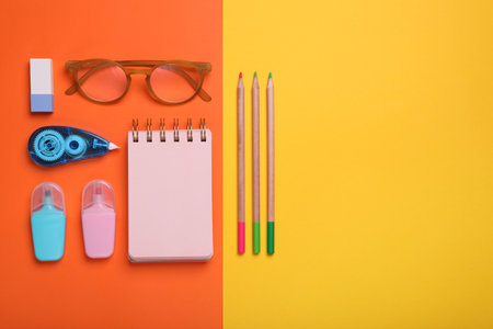 Flat lay composition with different school stationery and glasses on color background, space for text. Back to schoolの写真素材