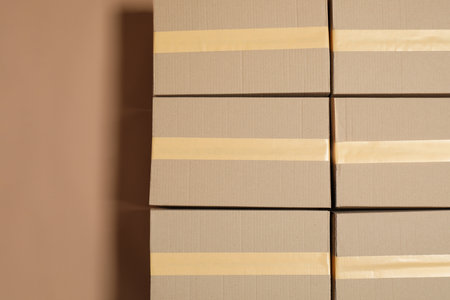 Cardboard boxes on light brown background, flat lay. Space for text