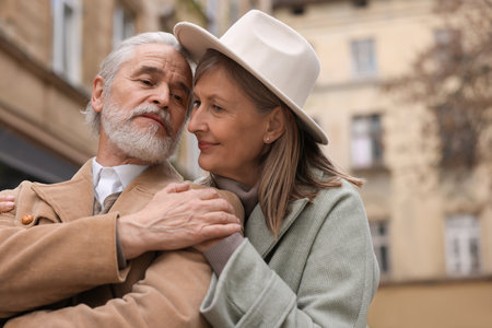 Portrait of affectionate senior couple walking outdoors, space for textの写真素材